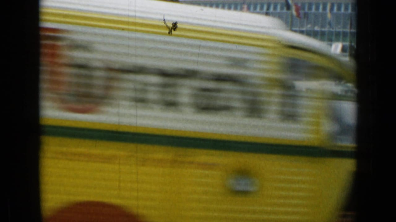 Yellow vehicle passes close to camera on a busy Cannes street.