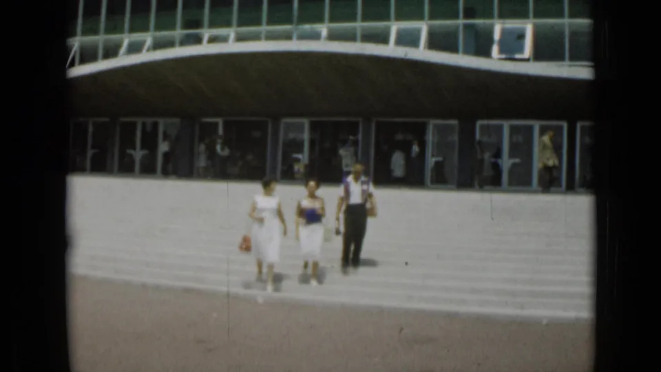 At the end of the 1962 Cannes shot, the group reaches lower on the steps as the curved glass-fronted building fills the background.