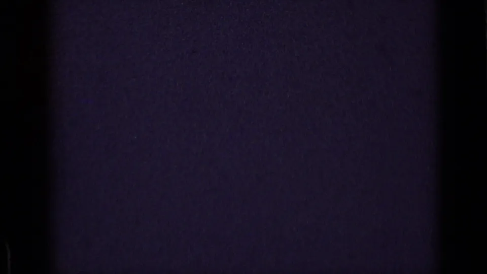 Dark end frame from the 8mm scan, showing film texture and color cast without a clear visible scene.