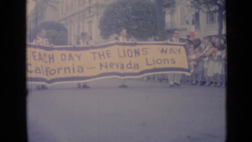 The Lions banner passes spectators in Cannes, with uniformed participants and building facades visible behind the parade route.