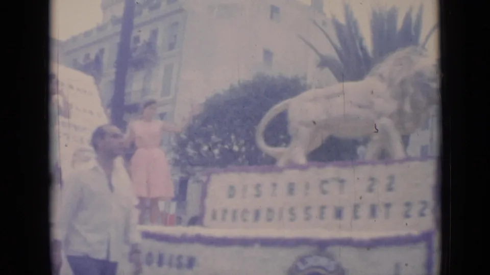 1962 Cannes parade float with a lion statue, a woman in a pink dress, and District 22 text visible on the side.