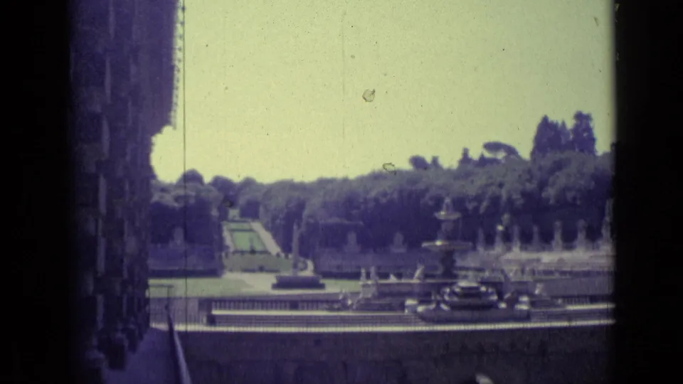 1962 Florence travel frame with formal fountains, manicured greenery, balustrades, and dark cars below the garden terrace.