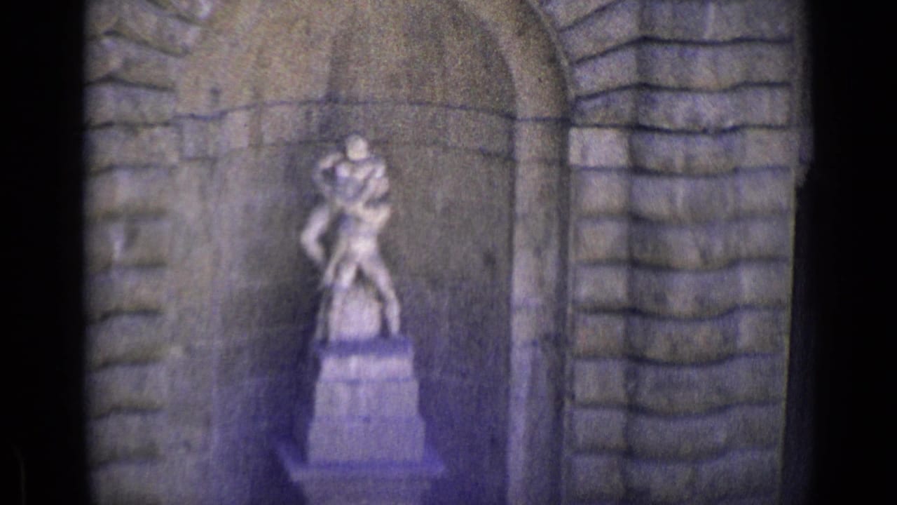Two-figure stone statue framed by an arched masonry recess.