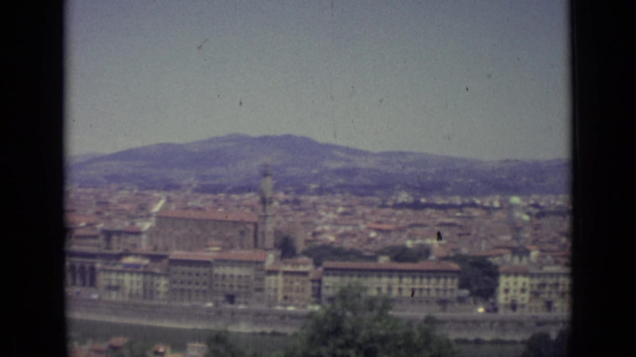 Soft 8mm view over Florence rooftops with hills in the distance.