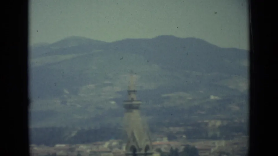 End of the 1962 Florence panorama with a church spire in the foreground distance and hills beyond.
