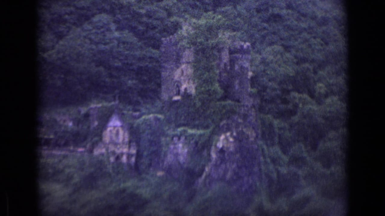 1962 German 8mm travel frame showing stone ruins and a small chapel-like structure set into a wooded cliffside.