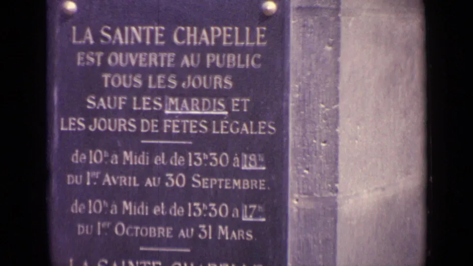 A French public-entry sign for La Sainte Chapelle appears on a stone wall, creating a location-review cue against the clip metadata.