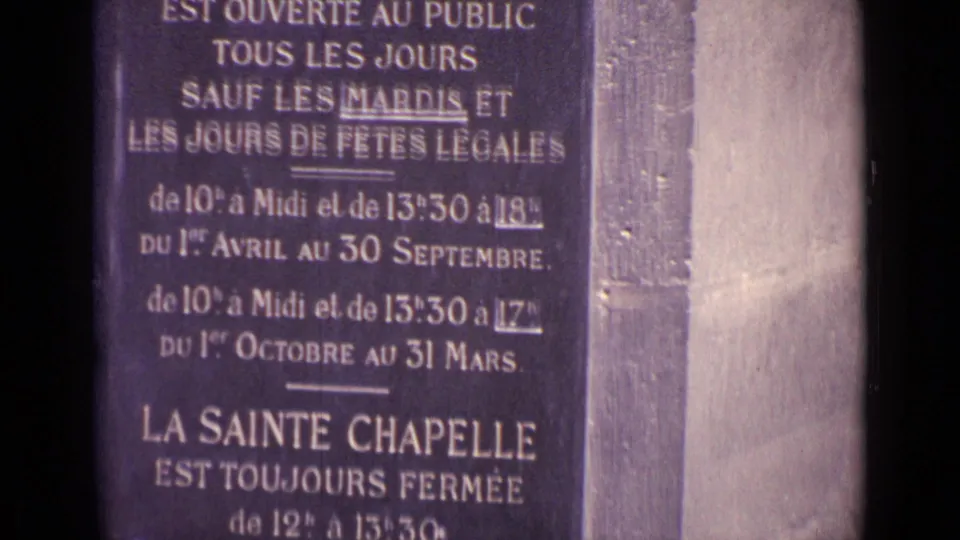 Cataloged 1962 8mm frame showing the lower part of a Sainte Chapelle sign, including midday closure wording.