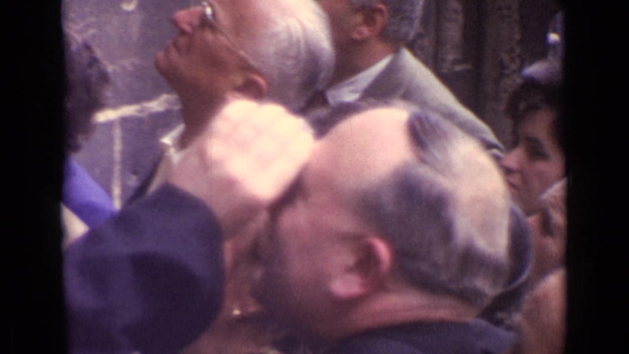 A 1962 Germany 8mm frame shows adults in period dress looking up inside a dim stained-glass interior.
