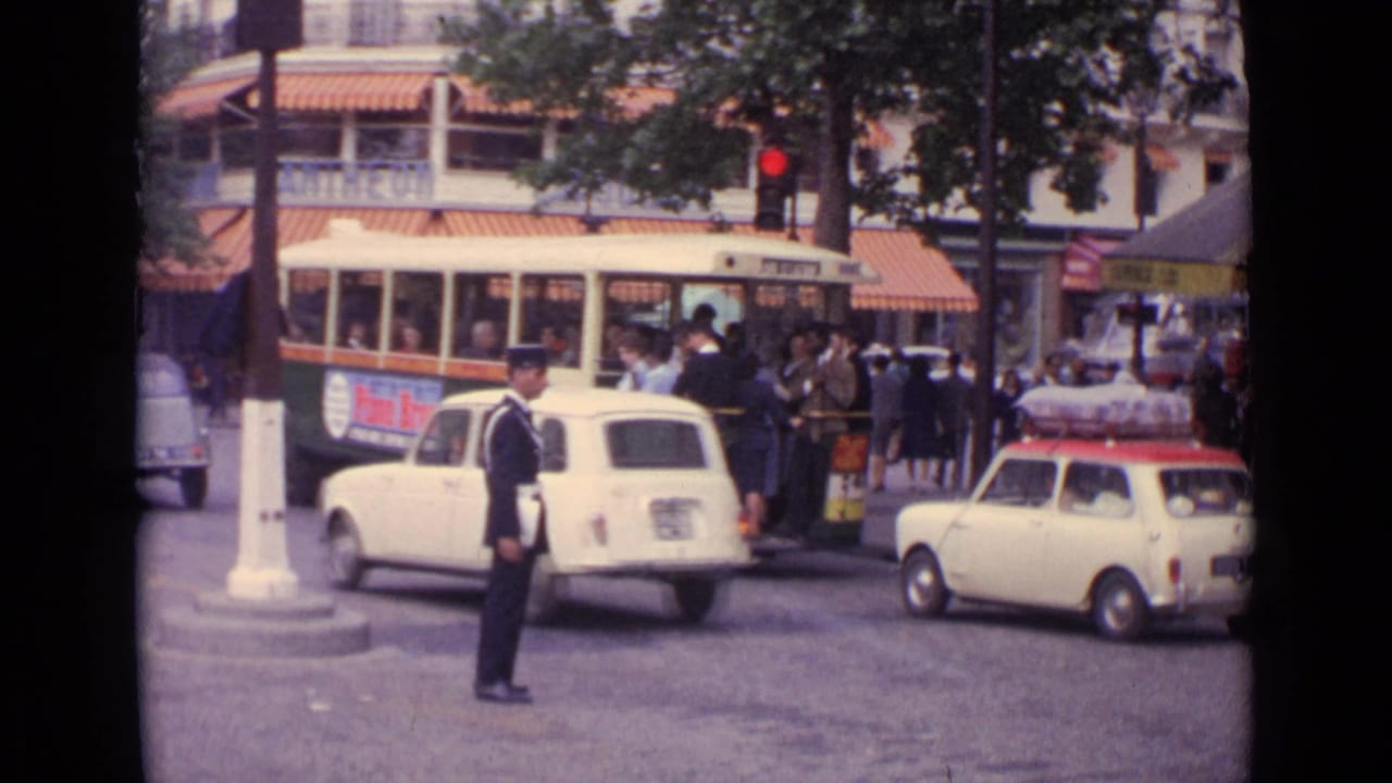 1962 Germany street scene with a uniformed traffic officer, compact cars, pedestrians, and a cream and green trolleybus.
