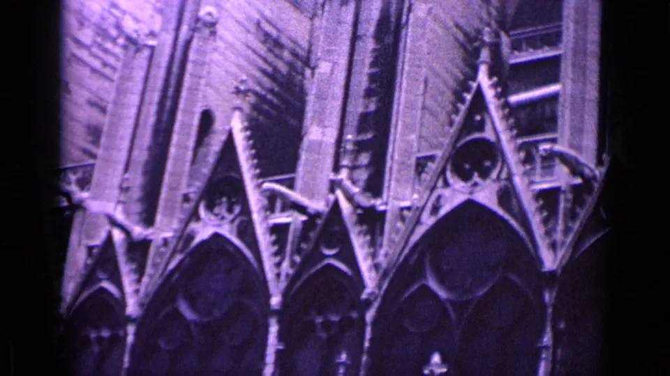 1962 Germany 8mm frame showing ornate Gothic stonework, triangular gables, and vertical cathedral wall details.