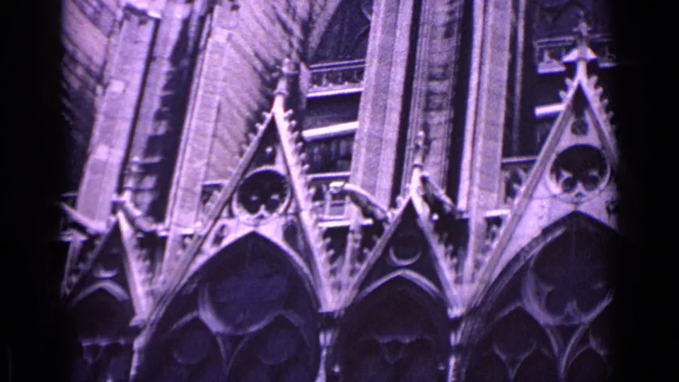 1962 Germany home-movie frame with Gothic cathedral arches, carved stone decoration, and a purple-tinted film appearance.