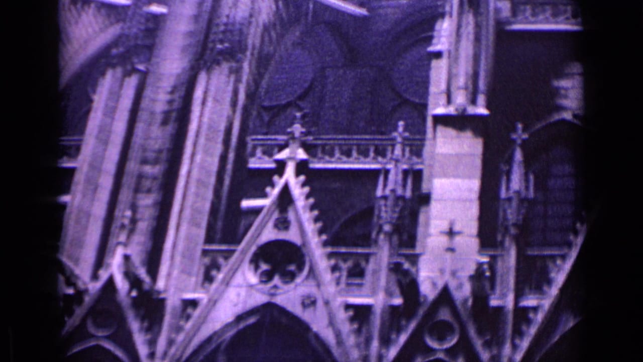 Gothic church facade with pointed gables, arched windows, pinnacles, and dark roof sections.