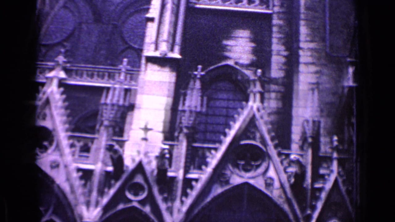 Closer view of Gothic stonework with triangular gables, arched openings, and roof detail.