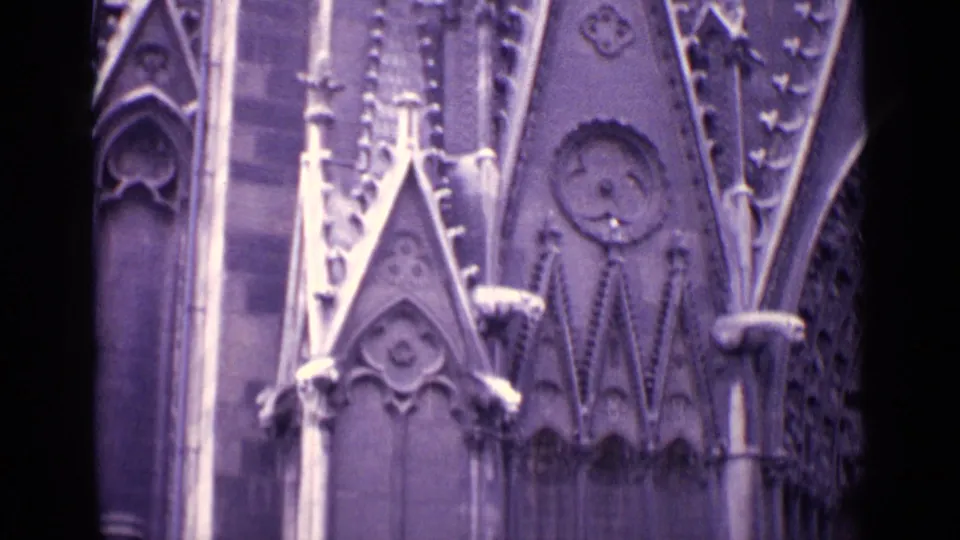 1962 Germany home-movie frame showing carved Gothic-style church facade details, pointed stone forms, tracery, and vertical columns.