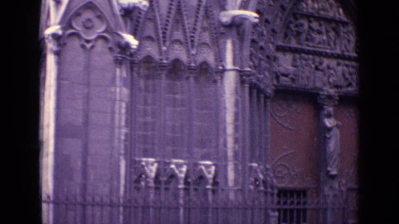 Church entrance area with carved stonework, iron gate, and large wooden doors.