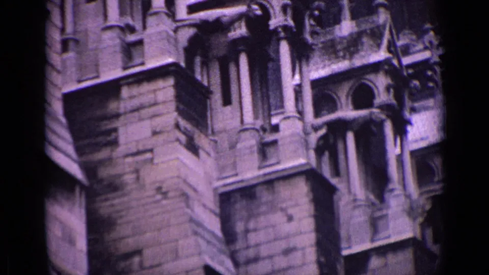 Close 1962 Germany home-movie view of carved stone figures, columns, and Gothic detailing on a historic church exterior.