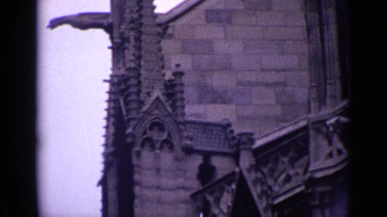 Stone church facade with ornate vertical detail, roof section, and dark arched recess.