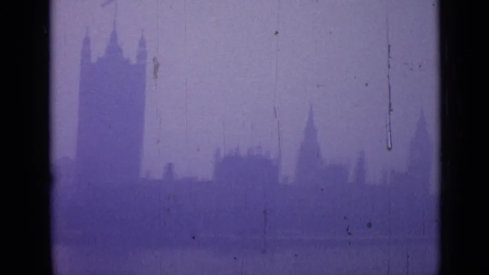 1962 London frame from the end of the pan, showing Westminster's skyline and Elizabeth Tower through foggy purple 8mm texture.