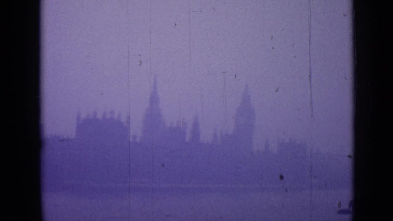 Fog-muted London skyline with a tall clock-tower form and nearby rooflines visible through aged 8mm color shift.