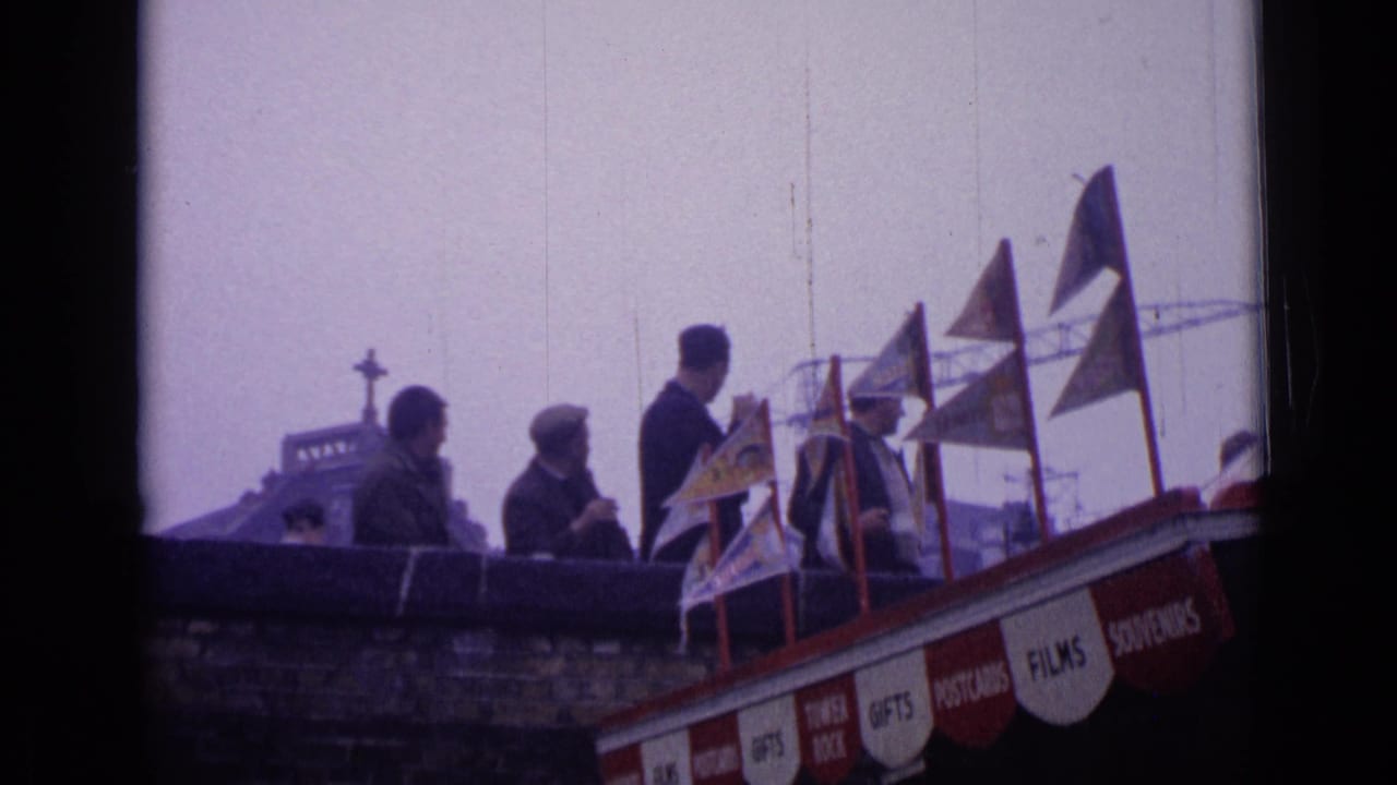 People stand above a street near flags and a souvenir stand sign.