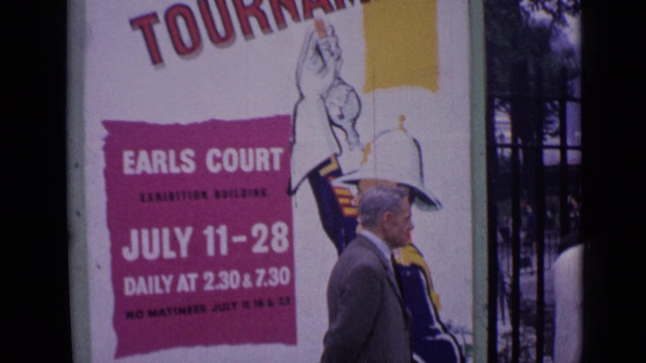 Royal Tournament poster beside an older man walking near iron gates.