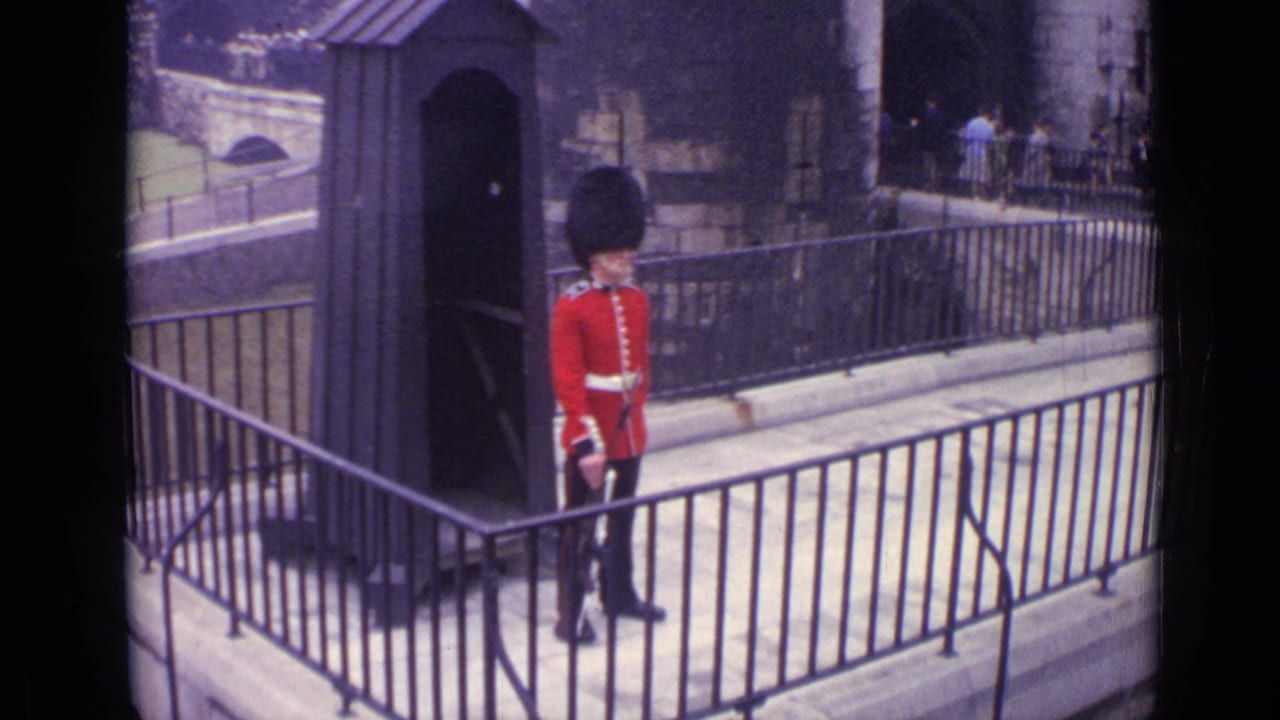 Red-uniformed guard stands on a walkway near a dark sentry box and railings.