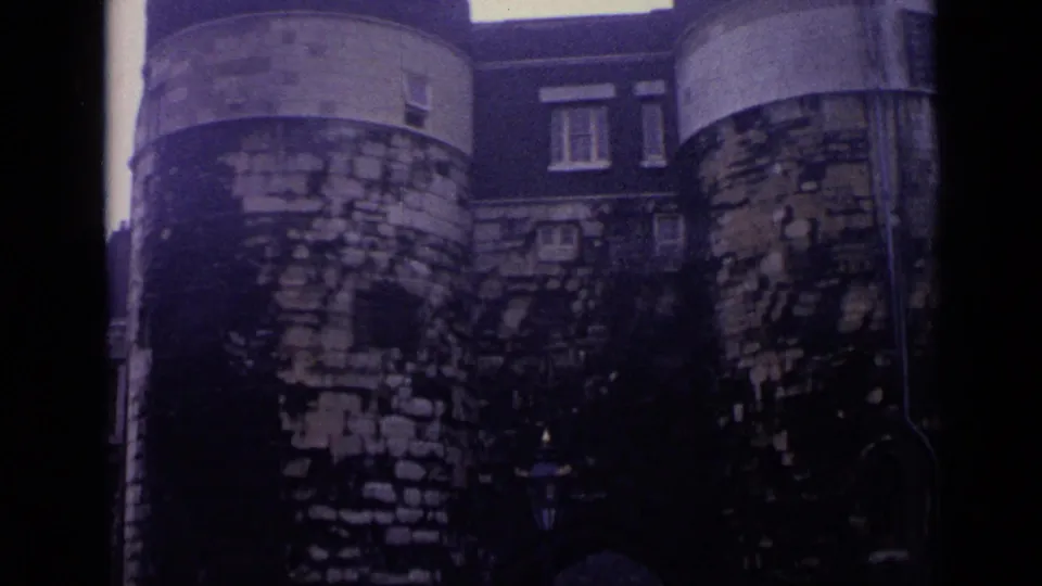 Weathered stone towers and masonry at the Tower of London appear in a brief architectural cutaway.