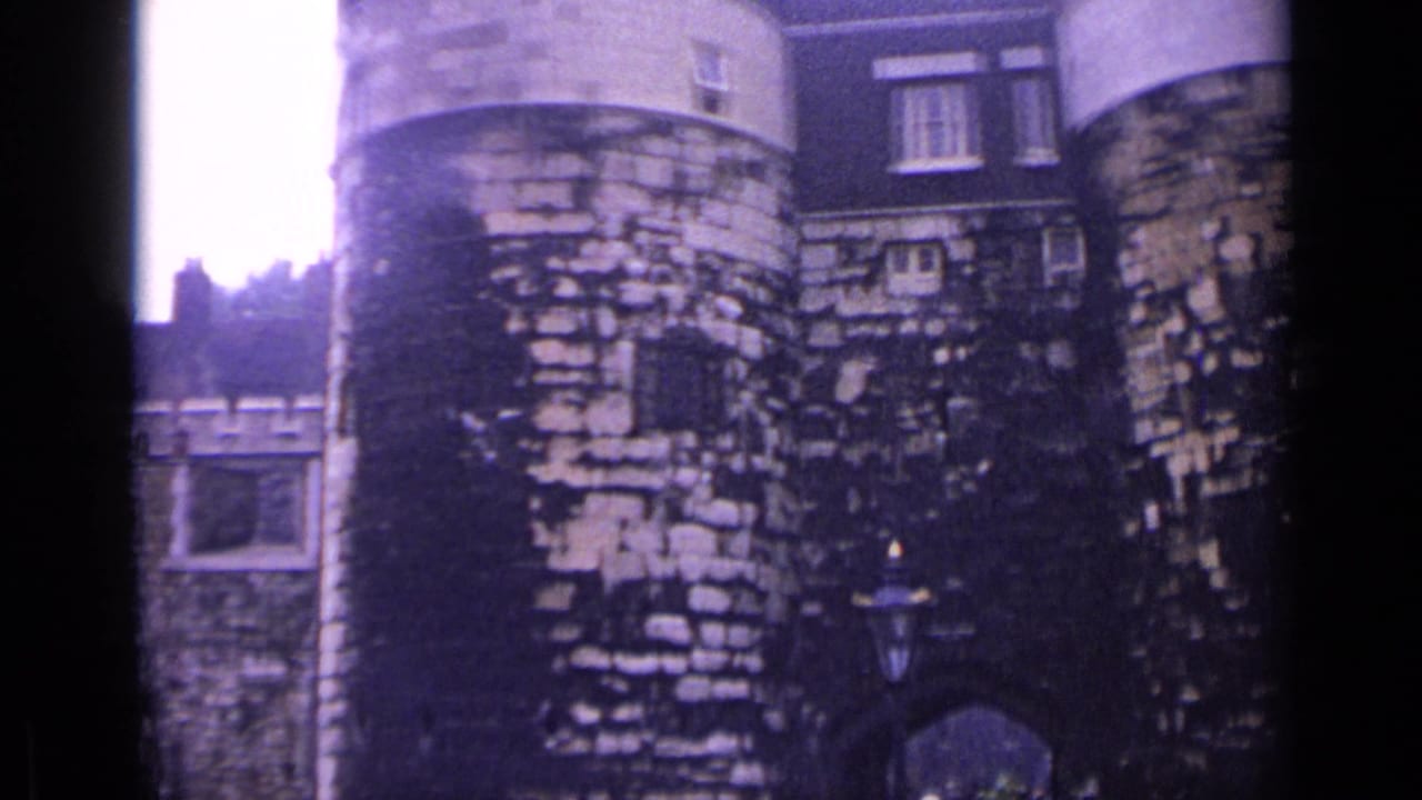 Round stone towers and weathered walls at the Tower of London under a bright cloudy sky.