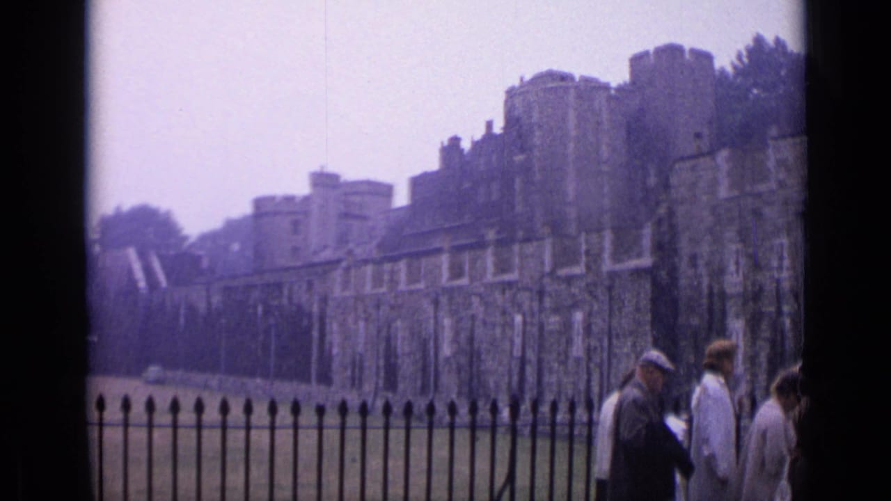 1962 London view of the Tower of London walls and lawn, with tourists partially visible near the frame edge.