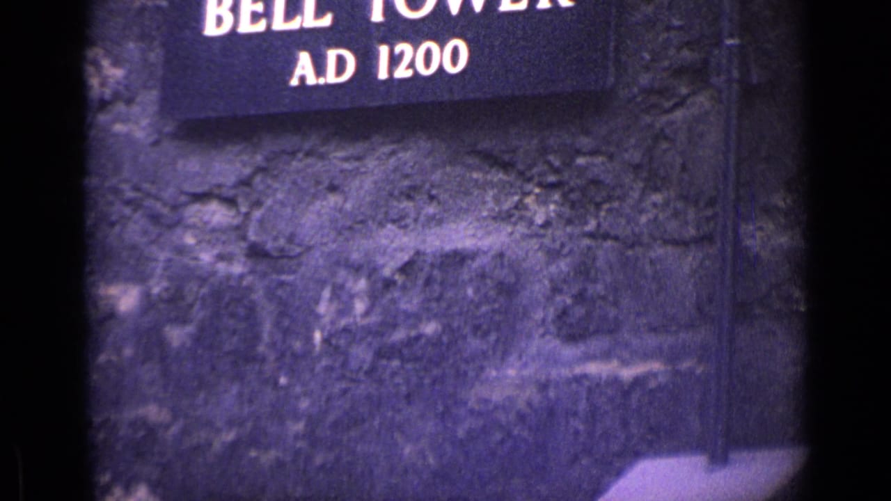 Partial Bell Tower sign above rough stone wall.