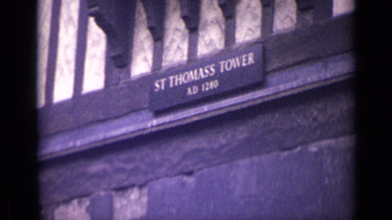 St Thomas Tower sign on a dark stone wall, with AD 1280 text visible above rough masonry.