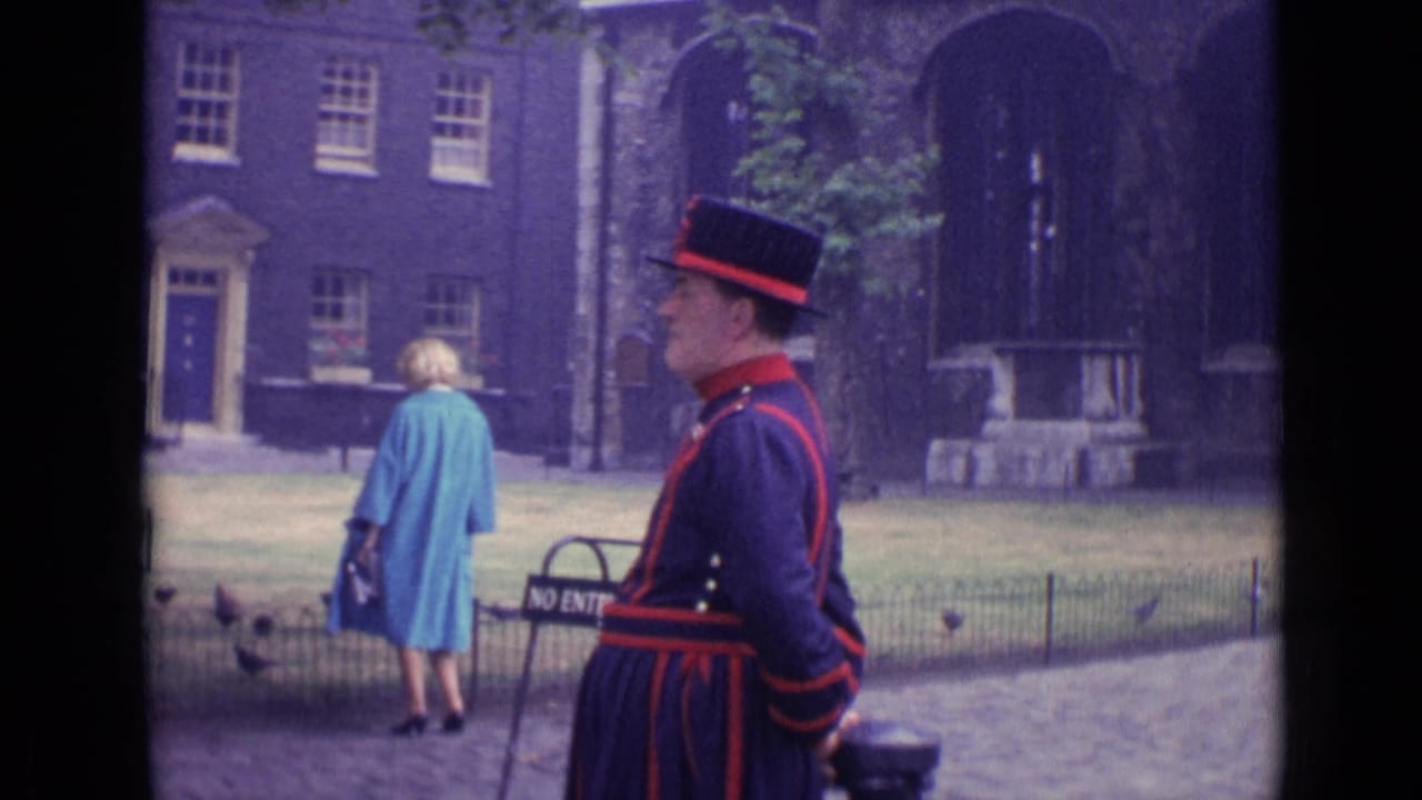 Ceremonial guard in dark uniform near a stone building as a woman in a blue coat walks away.