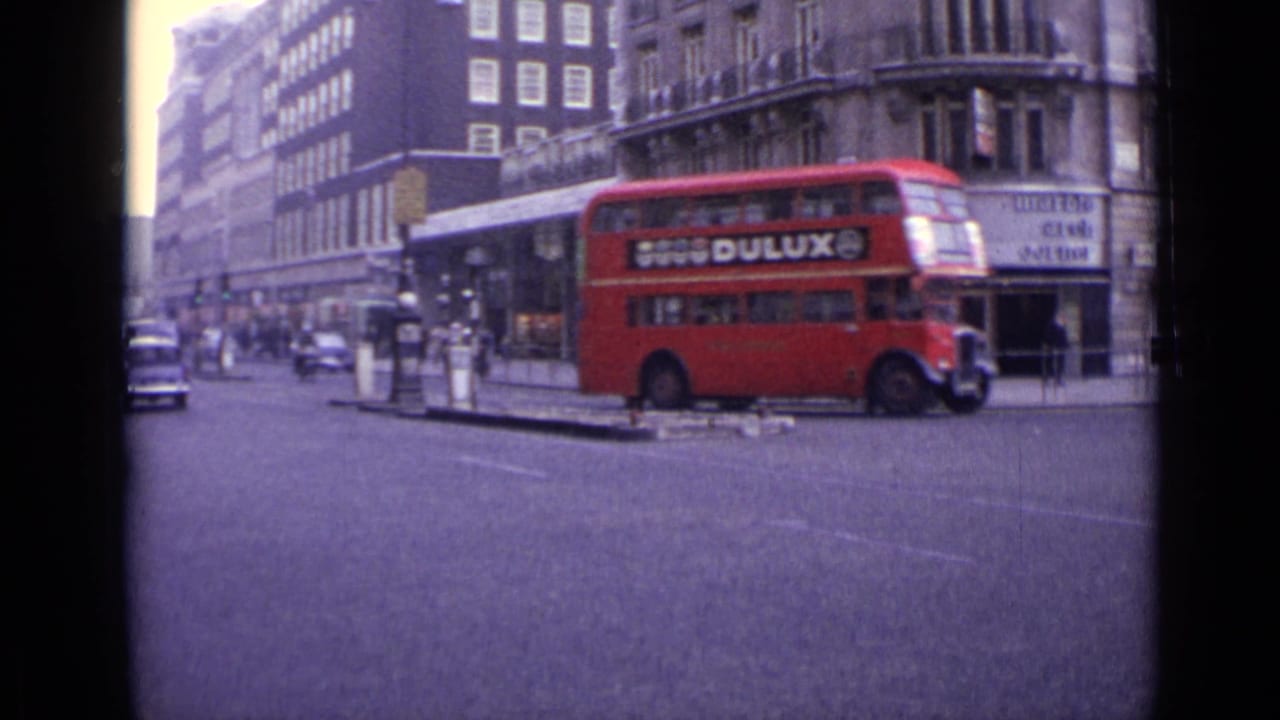 Red double-decker bus with Dulux advertisement beside a London traffic island.
