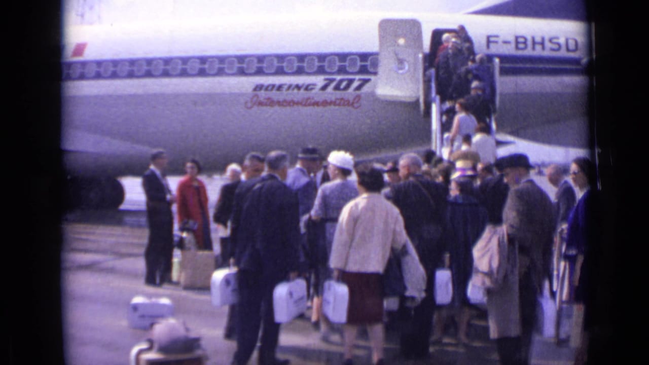 1962 airport tarmac view of passengers with luggage near a Boeing 707 Intercontinental marked with registration F-BHSD.