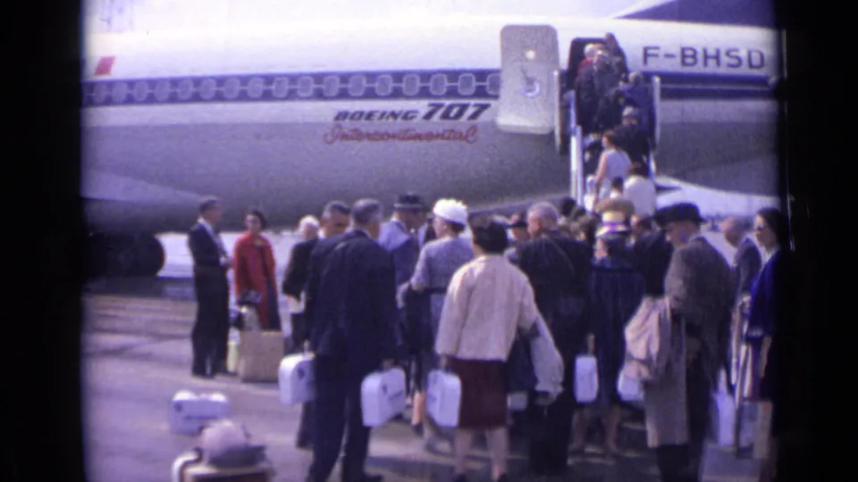 1962 airport tarmac view of passengers with luggage near a Boeing 707 Intercontinental marked with registration F-BHSD.