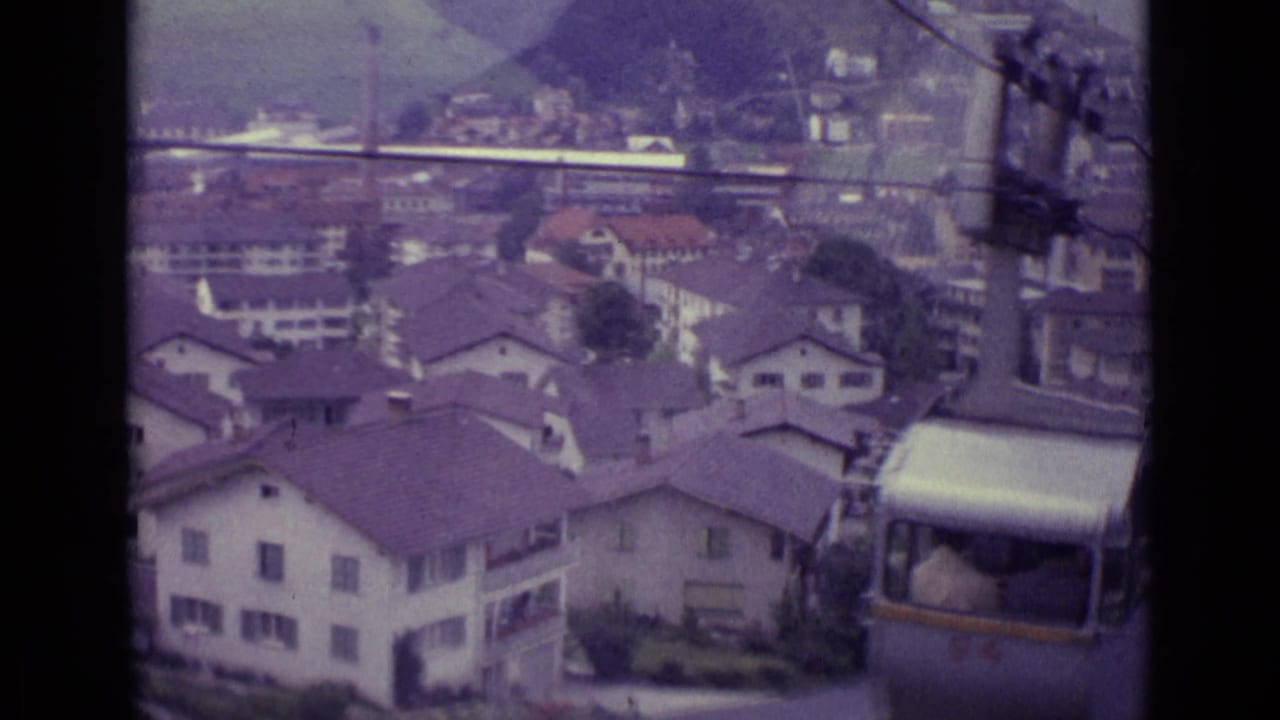 Lucerne rooftops and hillside seen from an elevated 1962 home movie, with a silver cable car partly visible at lower right.