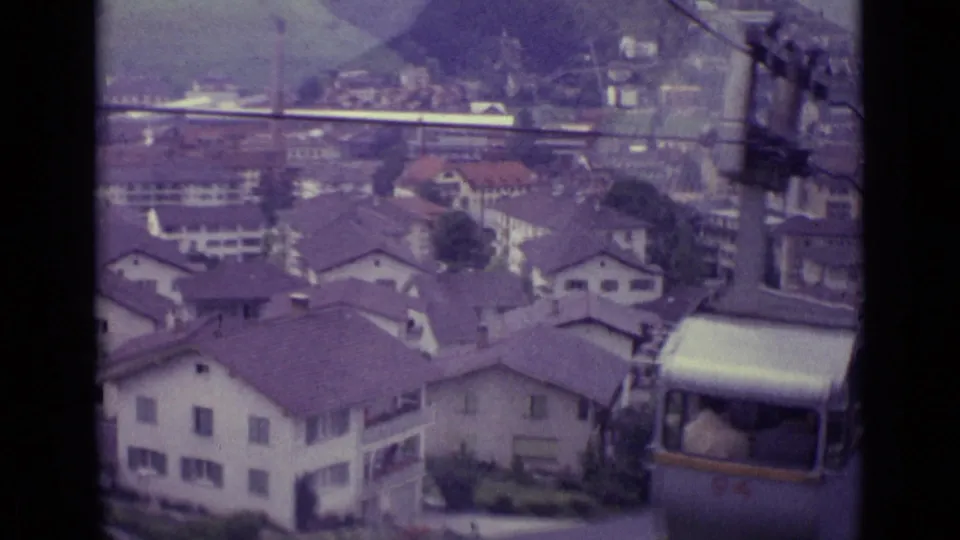 Lucerne rooftops and hillside seen from an elevated 1962 home movie, with a silver cable car partly visible at lower right.