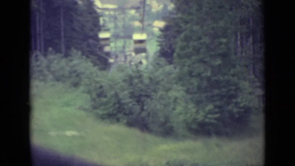 1962 cable-car view in Lucerne showing a green hillside, trees and small structures below the moving cabin.