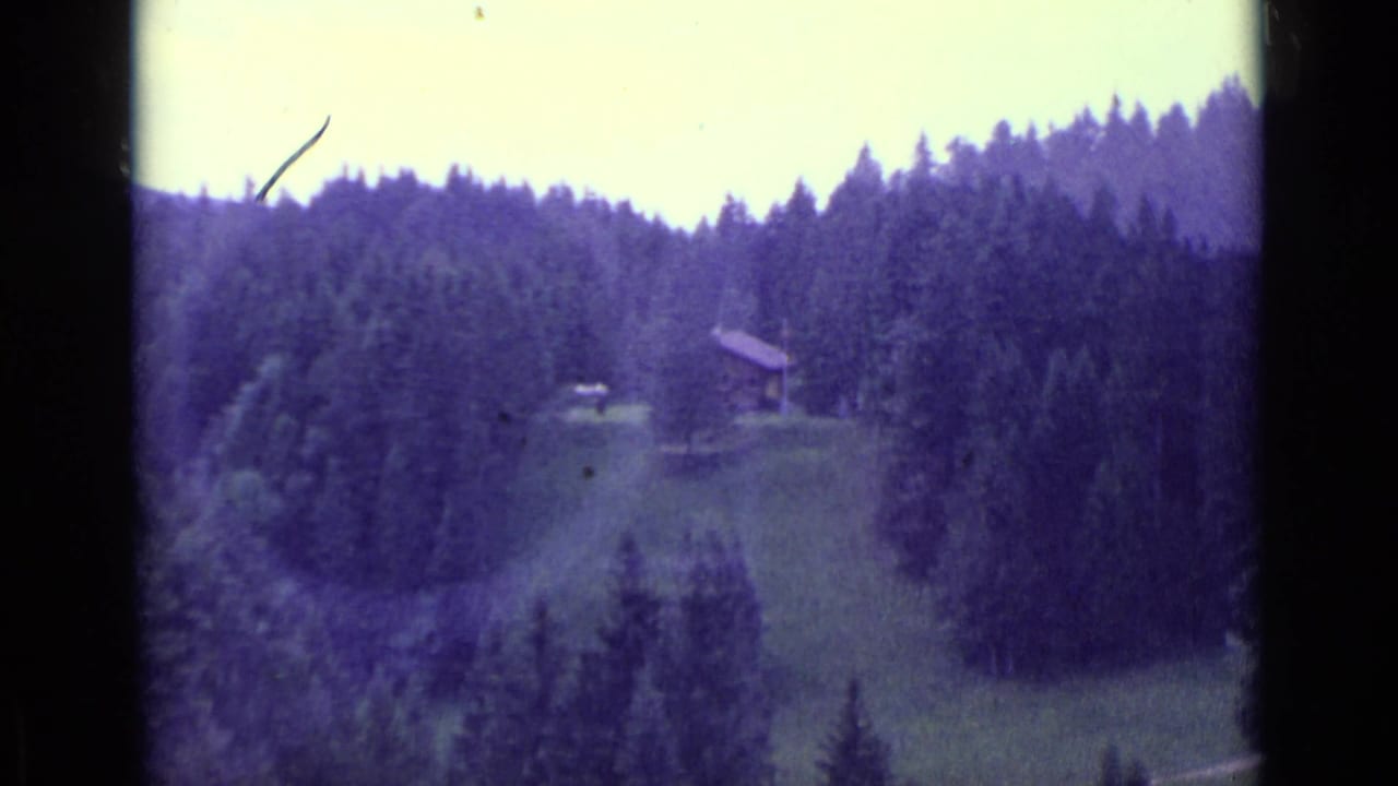 1962 Lucerne-area home-movie view of a forested Swiss hillside, meadow, and small mountain building.
