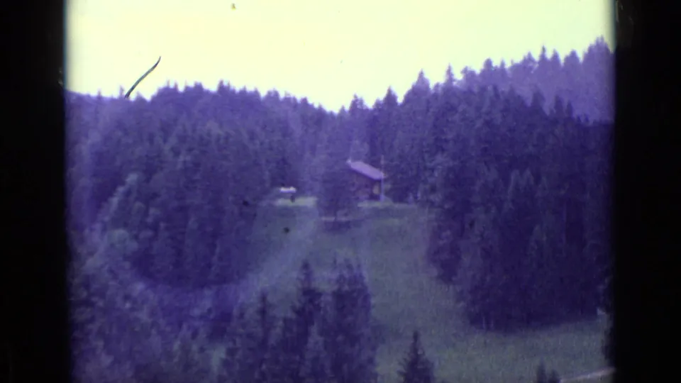 1962 Lucerne-area home-movie view of a forested Swiss hillside, meadow, and small mountain building.