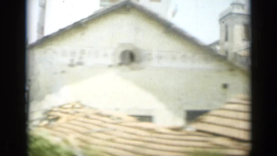 1962 Monaco street view of a pale gabled building, tile rooftops, and a dark window divider along the frame edge.
