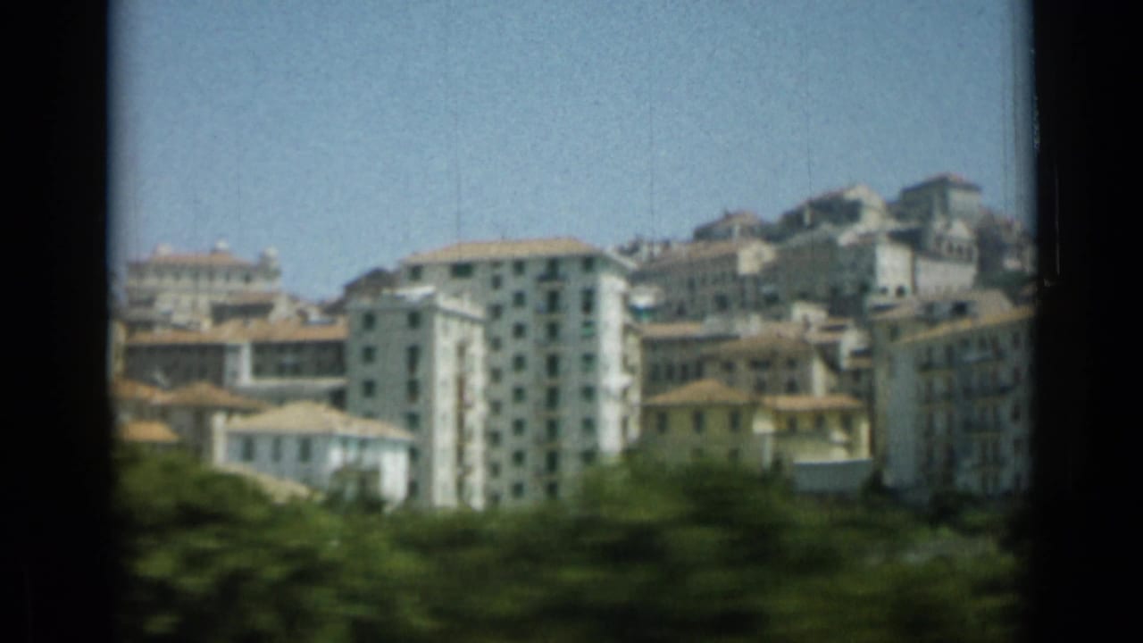 Hillside cluster of pale European buildings under a clear blue sky.
