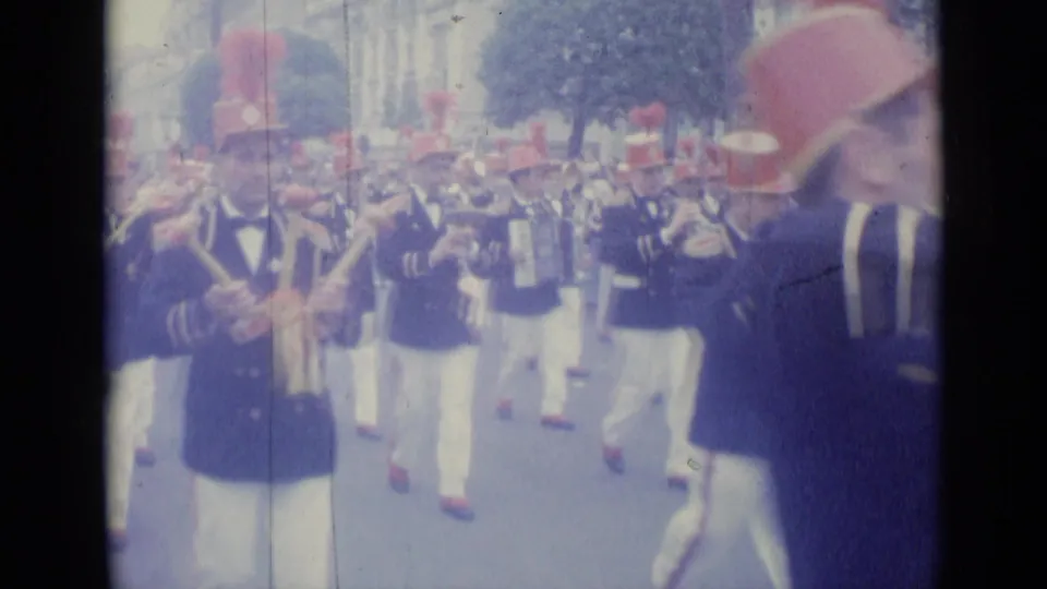 Final frame shows the 1962 Nice marching band continuing past the camera, with musicians, red plumed hats, and street spectators visible.