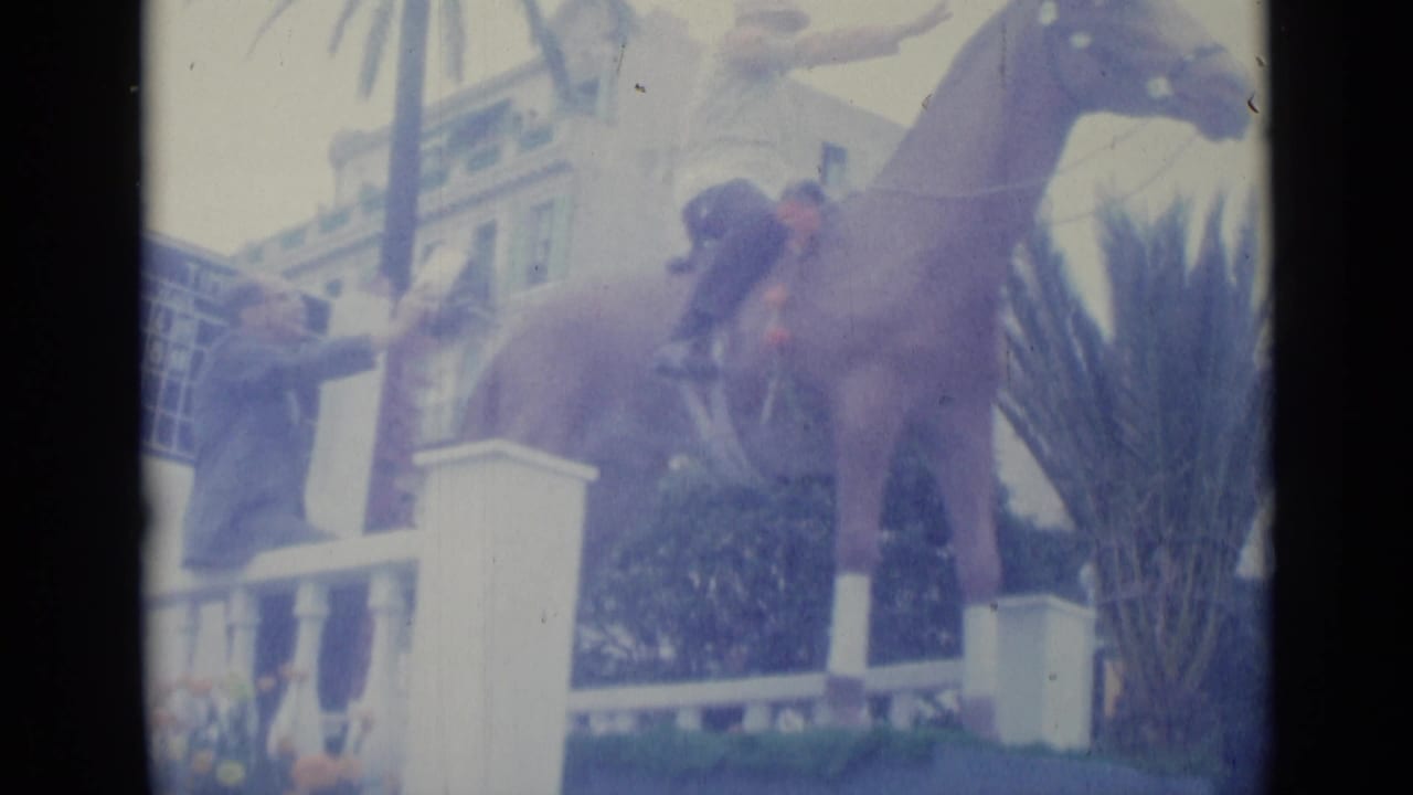 Horse and rider beside a railing with a blue timing board in the background.