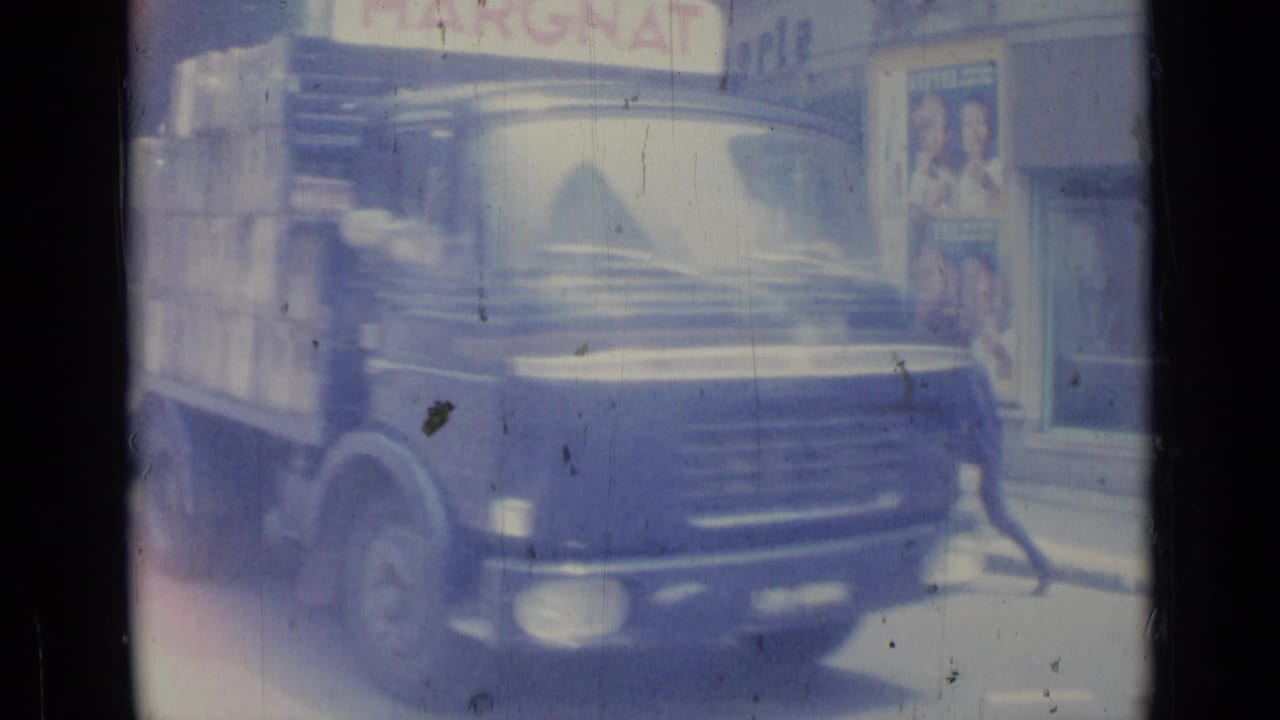1962 Nice street view with a dark delivery truck, pedestrians, storefronts, and visible Margnat signage on soft 8mm film.