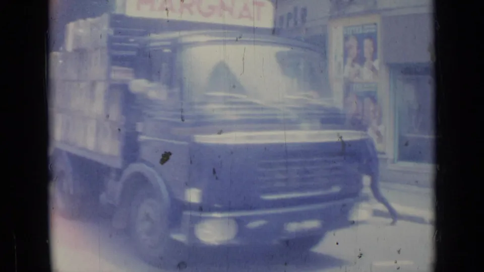 1962 Nice street view with a dark delivery truck, pedestrians, storefronts, and visible Margnat signage on soft 8mm film.
