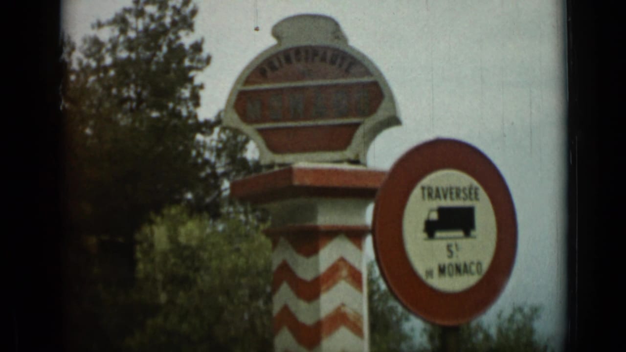 Roadside Monaco principality sign near Nice in 1962 home-movie footage, beside a red circular 5-ton truck-limit sign.