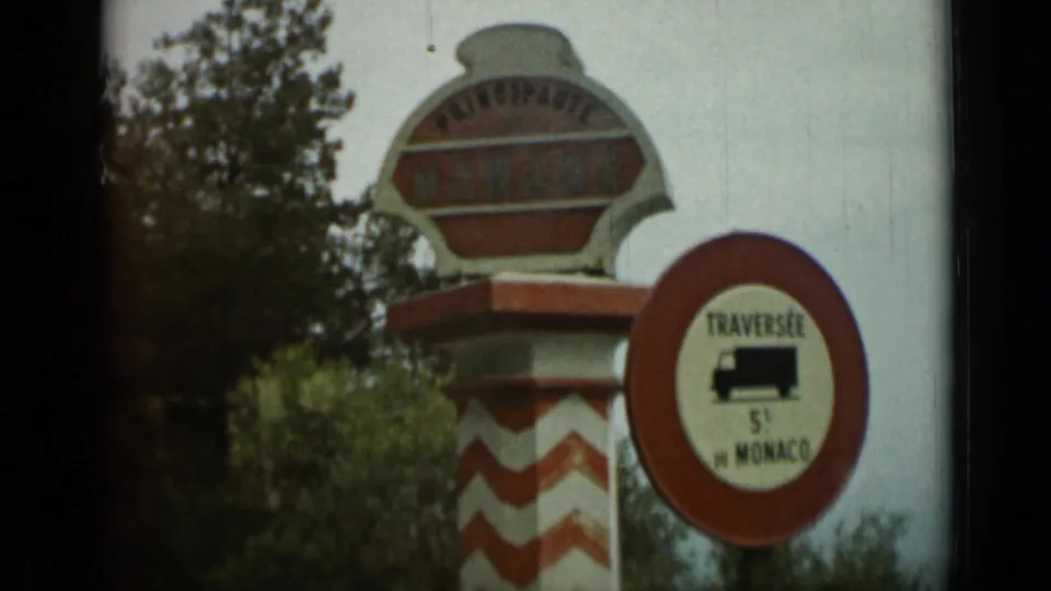 Roadside Monaco principality sign near Nice in 1962 home-movie footage, beside a red circular 5-ton truck-limit sign.