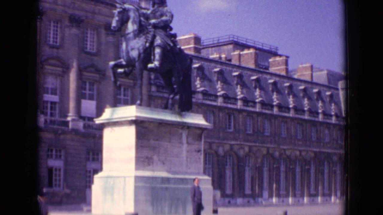 1962 Paris home-movie view of the equestrian monument and formal facade, framed tightly with a partial passerby at the bottom.